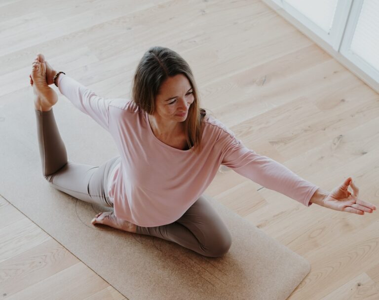 Nadine Alvermann-Kmetty in einer Yoga Pose auf dem Boden im Yogastudio.